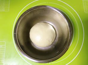 将面团整形成圆形，盖上保鲜膜放温暖处发酵。（最佳温度27度左右）