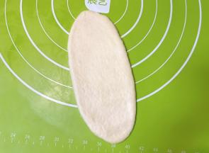 取一个面团擀成牛舌状（按照先后顺序，先拿最先包好的）。