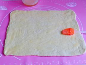 面团用擀面杖擀成薄片，均匀刷上炼乳酱。(留一点哈，刷表面)