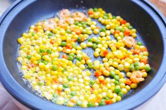 加入胡萝卜玉米粒豌豆翻炒至均匀裹上一层椰子油。