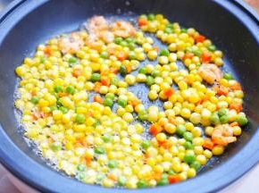 加入胡萝卜玉米粒豌豆翻炒至均匀裹上一层椰子油。