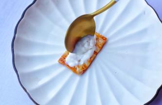 用勺子取一勺酸奶舀在烤好的酥皮上抹匀，