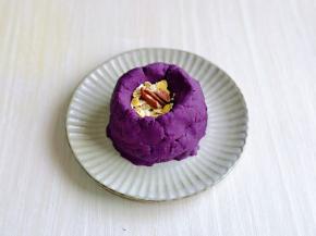 将紫薯泥，放入盘中，做一个类似鸟巢的样子，再放入一小勺燕麦，2个核桃仁。