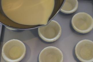 蛋挞皮提前回温（冷冻的蛋挞皮大概需要20分钟），蛋挞液倒入塔皮内八分满。