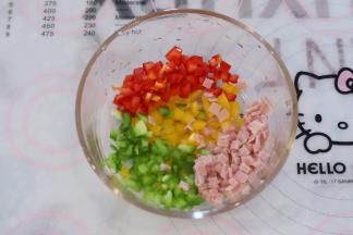 青椒红椒黄椒切成小粒，培根肉切成小块。