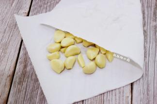 蒜头剥去外皮，冲洗一下，把头部切掉黄的部分，切掉薄薄的一片即可，一样也是用厨房用纸吸干水分