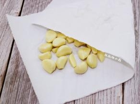 蒜头剥去外皮，冲洗一下，把头部切掉黄的部分，切掉薄薄的一片即可，一样也是用厨房用纸吸干水分