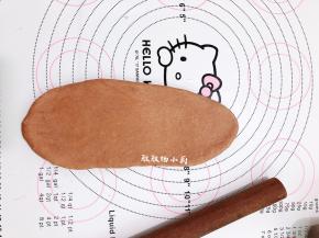 取一块面团，把小面团擀成椭圆形，借助刮板把面团翻面