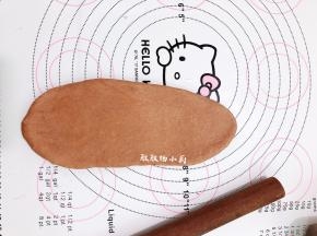 取一块面团，把小面团擀成椭圆形，借助刮板把面团翻面