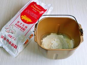 现在开始和面，将纯净水，盐，加盐可以增加风味和筋度，最后加入金龙鱼饺子专用麦芯粉，启动面包机揉面一个小程序。(这款面粉是饺子专用小麦粉，采用精选优质小麦，取麦芯的精华，饺子粉吸水性特别好，颜色也好看，口感特别好，揉面时的手感也很好，你会忍不住想多揉一会儿)