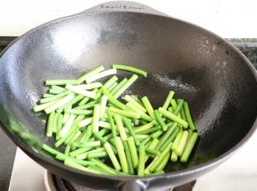 将铸铁锅清洗干净后重复步骤4、5，倒入蒜苔大火快速翻炒；