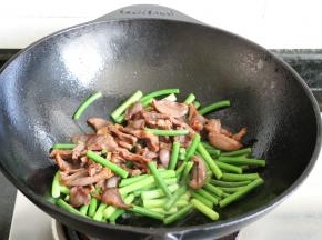 蒜苔炒软后倒入鸭肫片一起翻炒；