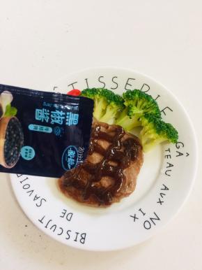 在牛排上挤上黑胡椒调料汁儿。