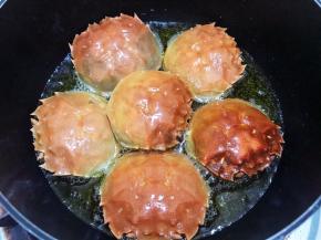 锅里放入稍微多一点的植物油（后面如果觉得油不够只能添加猪油）中小火放入蟹盖壳炸一会儿