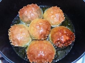 锅里放入稍微多一点的植物油（后面如果觉得油不够只能添加猪油）中小火放入蟹盖壳炸一会儿