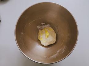 面团揉到稍微光滑放入软化好的黄油，低速揉匀，加盐转高速
