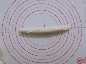 卷成长条状以后，收口卷紧，在案板上继续搓长一点。 如果面团回缩厉害，不容易搓长，就将它放在一边松弛一会儿，先做其他的面团。松弛到位以后就不会回缩。注意卷紧，卷到头以后收口处要捏紧