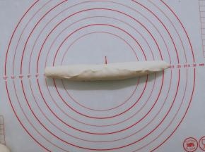 卷成长条状以后，收口卷紧，在案板上继续搓长一点。 如果面团回缩厉害，不容易搓长，就将它放在一边松弛一会儿，先做其他的面团。松弛到位以后就不会回缩。注意卷紧，卷到头以后收口处要捏紧