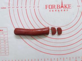 红曲面团搓成2条长条，一条切成小片，做成猪鼻子