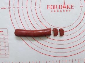 红曲面团搓成2条长条，一条切成小片，做成猪鼻子