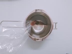 一小块巧克力放入裱花袋中，放入热水中融化。用来画猪猪眼睛，也可以用巧克力笔