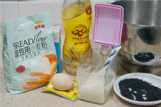 如图这款我们先来制作餐包，用料金龙鱼面包粉500克，牛奶400克，鸡蛋1个，白糖60克，玉米油50克，熟芝麻1碟，酵母4克，细盐5克