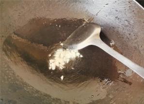 首先热锅倒入冷油，升温后，把蒜瓣切片放入锅中爆香。