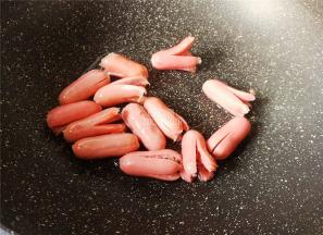 把切好的香肠全部倒入锅中，等待受热煎制。