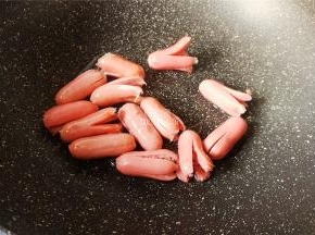 把切好的香肠全部倒入锅中，等待受热煎制。