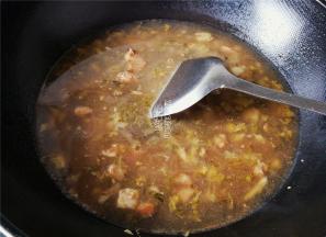 炒制片刻后，倒入炖煮好的牛肉汤和一些清水，大火煮沸。