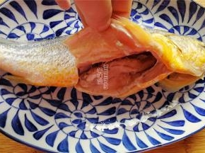 首先把黄鱼刮鳞去腮洗净，把内脏挖掉，去掉里面的黑膜。