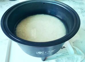 首先把米浸泡一会，倒入甑子中沥干，取电饭煲内胆倒入清水，把甑子装入内胆中。