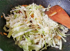 最后把卷心菜切丝，倒入锅中跟年糕一起翻炒均匀，炒制变软，炒熟即可。