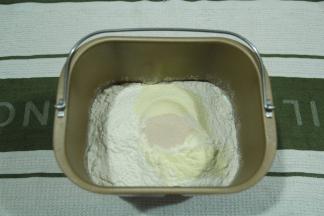 然后倒入粉类，上方挖个小洞，将干酵母倒入。先液体后粉类的顺序。