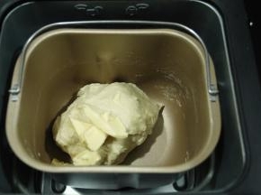 此时可以加入软化好的黄油，继续打面。直到程序差不多结束，可以取一点面团拉开观察一下，能拉出比较完整且略薄的膜，小餐包不像吐司，吐司需要手套膜，小餐包没有这么高要求。