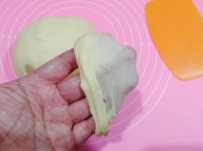 看，这种程度就可以做餐包，取出面团，双手握住面团，往外侧折叠收圆。