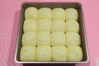 取出发好的餐包生胚，预热烤箱，上下180度。然后给餐包生胚刷一层全蛋液，撒上芝麻，白芝麻，黑芝麻都可以！