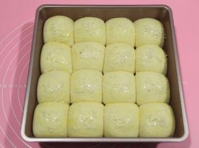 取出发好的餐包生胚，预热烤箱，上下180度。然后给餐包生胚刷一层全蛋液，撒上芝麻，白芝麻，黑芝麻都可以！