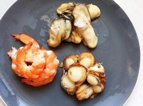 把温热的牡蛎、扇贝去壳，扇贝去掉肠胃发黑的部位整理干净，码盘备用。