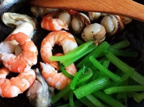 锅中加一点底油，下入海鲜翻炒均匀，加入西芹翻炒片刻。