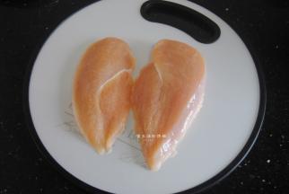 接下来把鸡胸肉上下分成2半，因为整个的鸡胸肉是很厚实的，要是直接做成一块，会很大块，不仅操作起来不方便，还不好炸透。