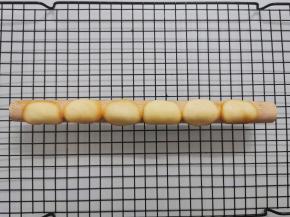 取出烤盘，趁热将烤好的薄饼铲起，放在圆形的小擀面杖（或其他细长的棍状工具）上，使它弯曲。等面糊冷却后会定型，变脆。 也可以直接用手将薄饼弯曲的。但如果你怕烫，还是带上隔热手套操作比较好。 烤好的薄饼要趁热立刻弯曲。冷却以后会变脆，就弯折不了了