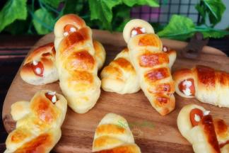 白巧克力隔水融化，在脆皮肠上装饰，画出眼睛来。木乃伊面包就做好了。