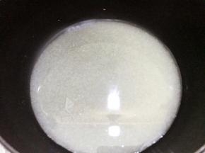 奶锅里放入白糖和清水轻轻晃动铺平