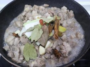倒入羊肉翻炒，变色出油后，加入葱姜蒜八角桂皮香叶干辣椒翻炒。