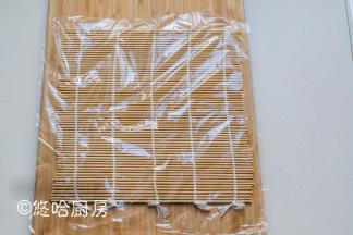 在案板上铺卷帘（做寿司用的卷帘），再铺一张保鲜膜。