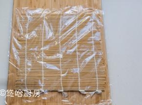 在案板上铺卷帘（做寿司用的卷帘），再铺一张保鲜膜。