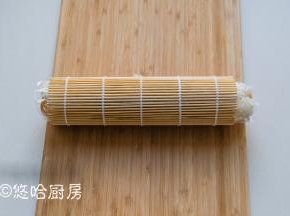 用卷帘将米饭卷起，卷的紧一点。