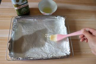 在烤箱配套的炸篮里铺一层锡箔纸，刷上一层橄榄油；
