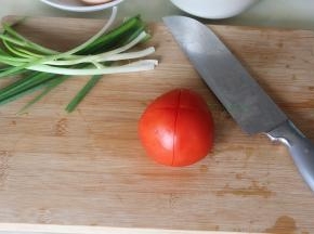 香葱洗净，切葱花。西红柿外皮用盐搓洗，然后用水冲洗干净，用刀在西红柿的划十字。划十字是为了去皮容易。